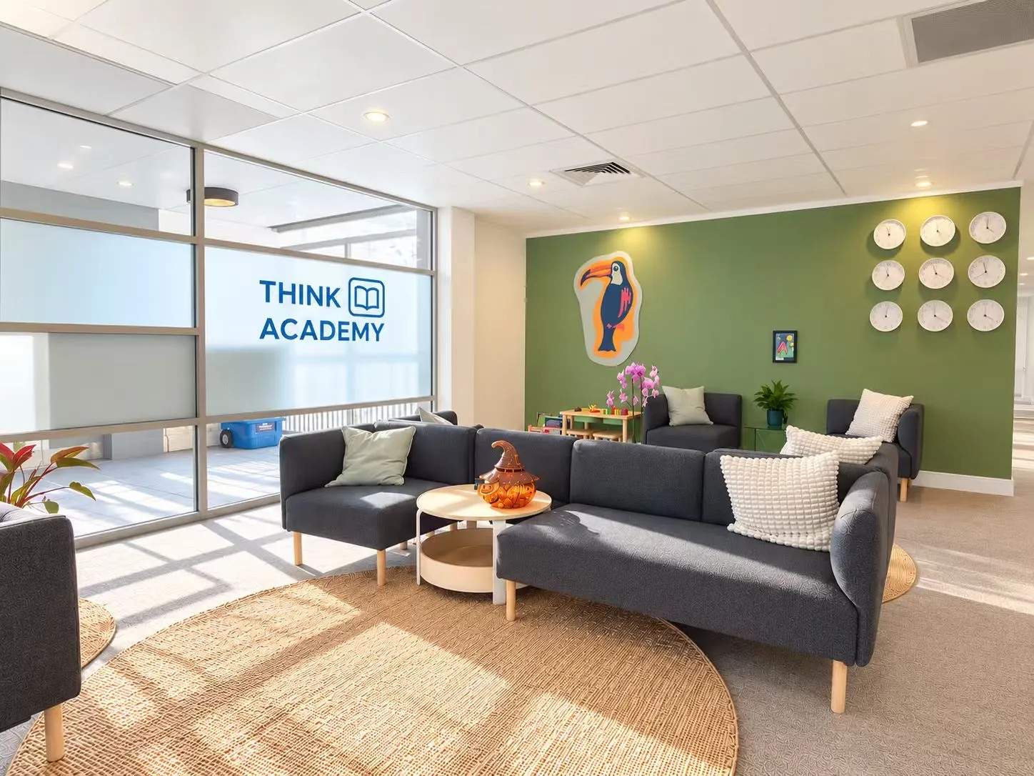 The Think Academy reception lounge, with the logo on the glass and a green feature wall